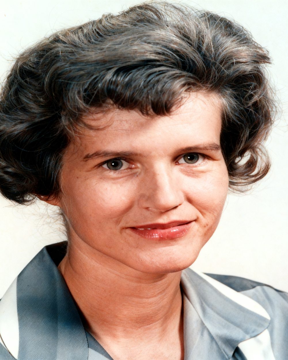 The same studio portrait in colour, with natural skin tones and a blue blouse.